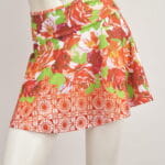 Red and green flower short skirt on dummy, ideal for the summer season, with a lively and fresh design.