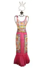 Colorful long dress with floral details, presented on a stylized hanger. The design includes thin straps and a wide skirt with ruffles, ideal for summer occasions and ceremonies.