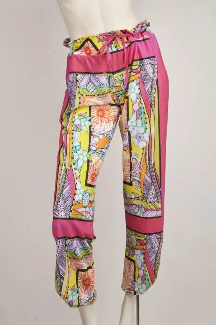 Pantaloni estivi da donna con motivo floreale colorato, realizzati in tessuto leggero e traspirante, ideali per outfit casual e da spiaggia.