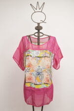 Top d'été coloré à manches courtes, avec un motif floral vivant et des détails en maille rose. Présenté sur un mannequin décoratif avec une couronne. Idéal pour les tenues d'été et les occasions décontractées.