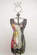 Abito estivo colorato su manichino, con motivi grafici vivaci e scollatura ampia, ideale per look casual e alla moda.