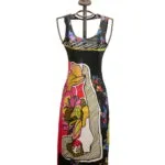 Abito lungo floreale con dettagli colorati, esposto su un manichino elegante con una corona in cima. Design moderno e vivace, ideale per occasioni estive e casual.