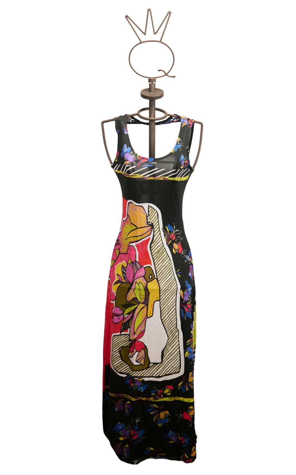 17SSNG462_a Abito lungo floreale con dettagli colorati, esposto su un manichino elegante con una corona in cima. Design moderno e vivace, ideale per occasioni estive e casual.