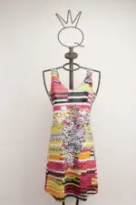 Abito estivo colorato con stampa floreale e righe, esposto su un manichino in metallo con una corona decorativa. Ideale per occasioni informali e look estivi.