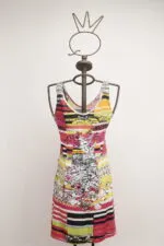 Abito estivo colorato con motivi floreali e strisce, esposto su un manichino artistico. Perfetto per occasioni informali e giornate calde.