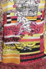 Dettaglio di una camicia colorata con motivi floreali e fruttati, caratterizzata da strisce vivaci in tonalità rosa, giallo e nero. Ideale per look estivi e freschi.