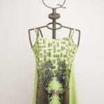 Robe vert clair à fines bretelles et imprimé floral, présentée sur un mannequin au design moderne. Idéale pour l'été et les occasions décontractées. 