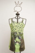 Robe vert clair à motifs floraux et géométriques, présentée sur un mannequin en métal. Modèle original, idéal pour la saison estivale.