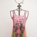 Robe d'été sans manches à l'imprimé floral et aux motifs géométriques, présentée sur un mannequin artistique. Un design vif et coloré idéal pour la saison chaude. 