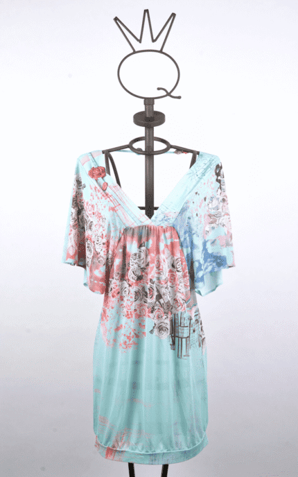 Summer dress with bell sleeves, presented on a mannequin. The dress features a floral design in shades of blue and pink on a light blue background, ideal for casual occasions and summer days.