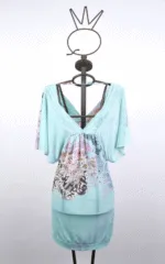 Abito estivo leggero in tessuto azzurro con maniche ampie e motivo floreale, esposto su un manichino con supporto decorativo. Ideale per look casual e freschi.