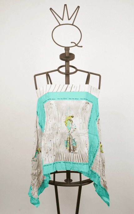 Top in tessuto leggero con stampa colorata di piume, esposto su un manichino. Design estivo ideale per outfit casual e freschi.
