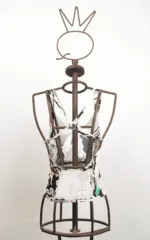 Manichino di abbigliamento che espone un top multicolore con dettagli artistici, su sfondo bianco.