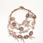 Collana artigianale con perline in vetro e dettagli in bronzo, caratterizzata da un design elegante e moderno, perfetta per completare qualsiasi outfit.