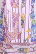 Abito con stampa colorata e vivace, caratterizzato da motivi floreali in tonalità rosa, gialla e blu. Design moderno e originale, ideale per la stagione estiva.