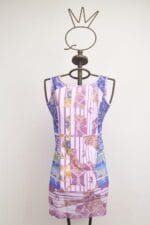 Robe d'été colorée dans les tons violet et rose, avec un motif géométrique et floral, présentée sur un mannequin avec une tête en forme de couronne.