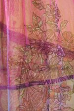 Tessuto in maglia jacquard e tulle con stampa a fiori, caratterizzato da tonalità rosa e dettagli floreali intricati, ideale per un vestito elegante e primaverile.